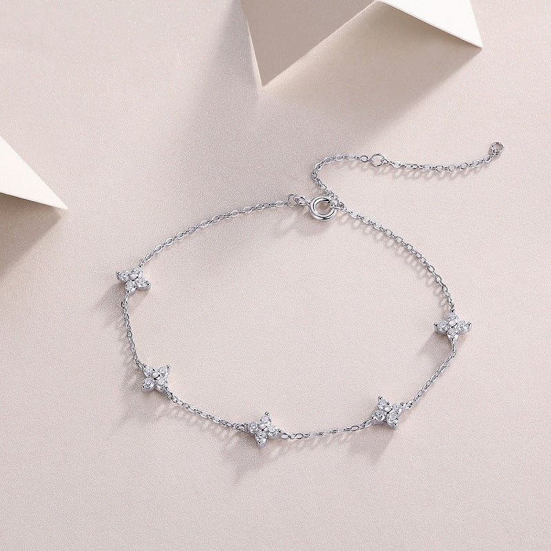 Delicate silver flower moissanite bracelet on soft white geometric background