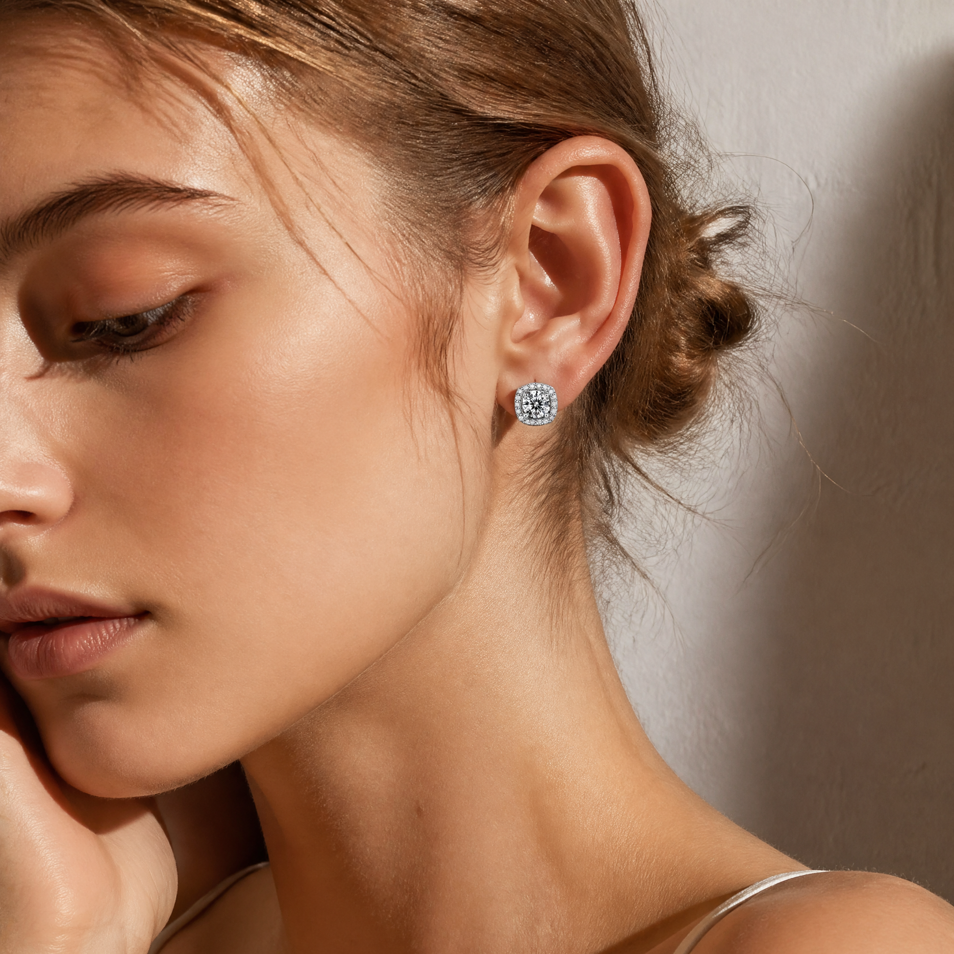 Side profile of woman wearing cushion halo moissanite stud earrings
