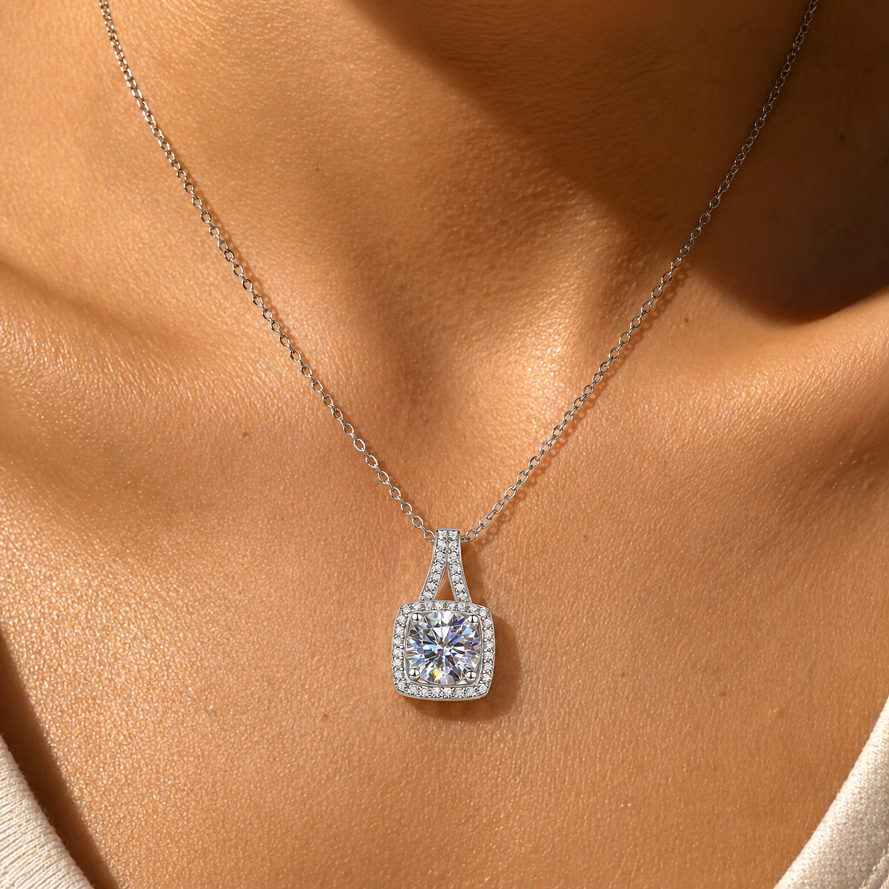 Close-up of cushion halo moissanite pendant necklace on sun-kissed skin