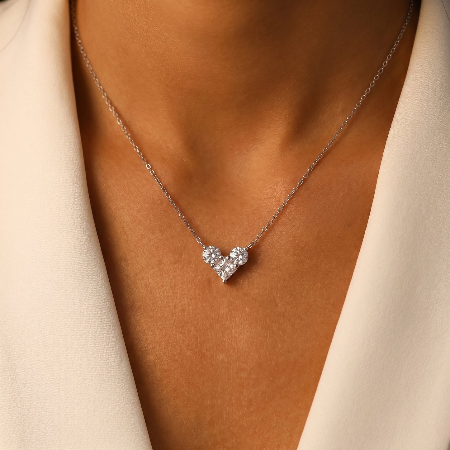 Luxury everyday style featuring Luvia 1 carat geometric heart pendant necklace worn by a model in soft warm lighting.