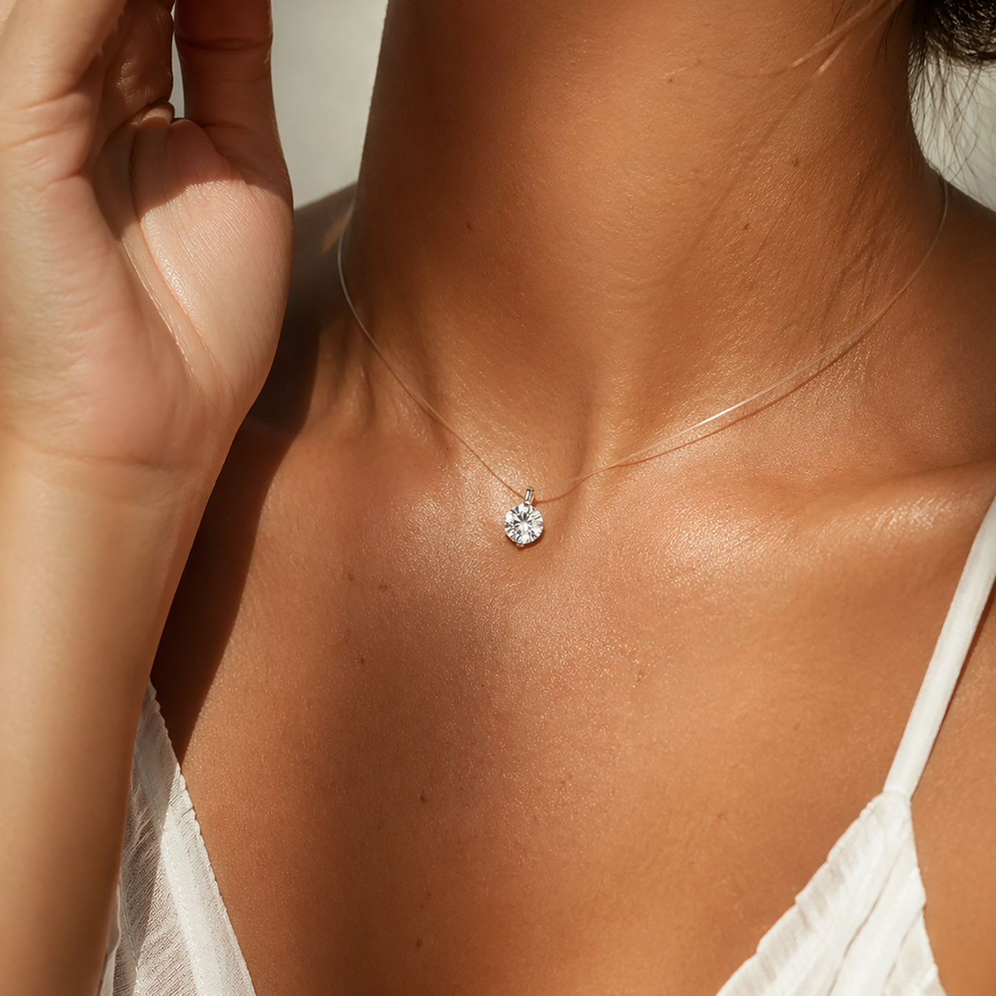 Woman wearing an invisible line moissanite pendant necklace on sun-kissed skin