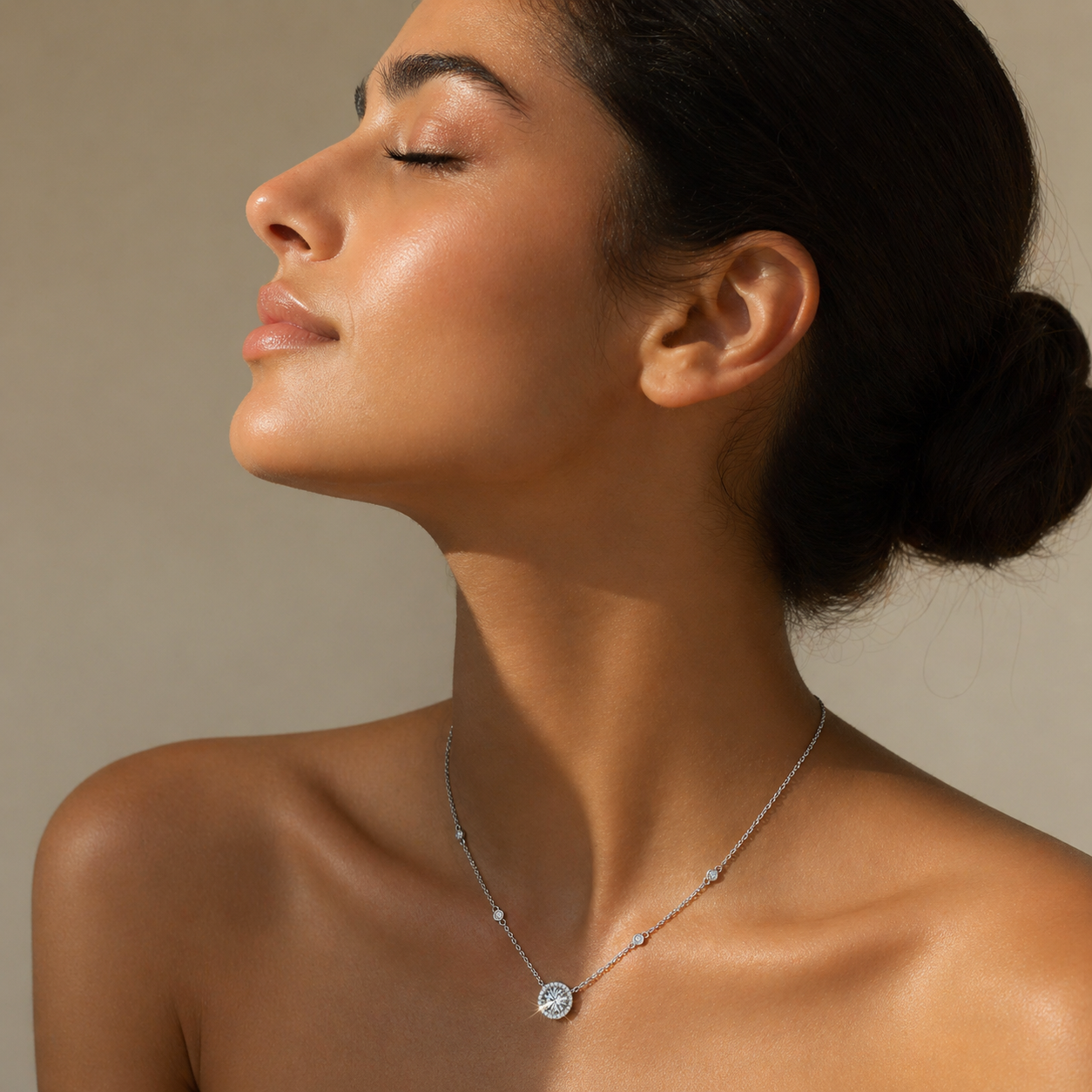 Woman wearing a round halo moissanite pendant necklace in soft warm sunlight