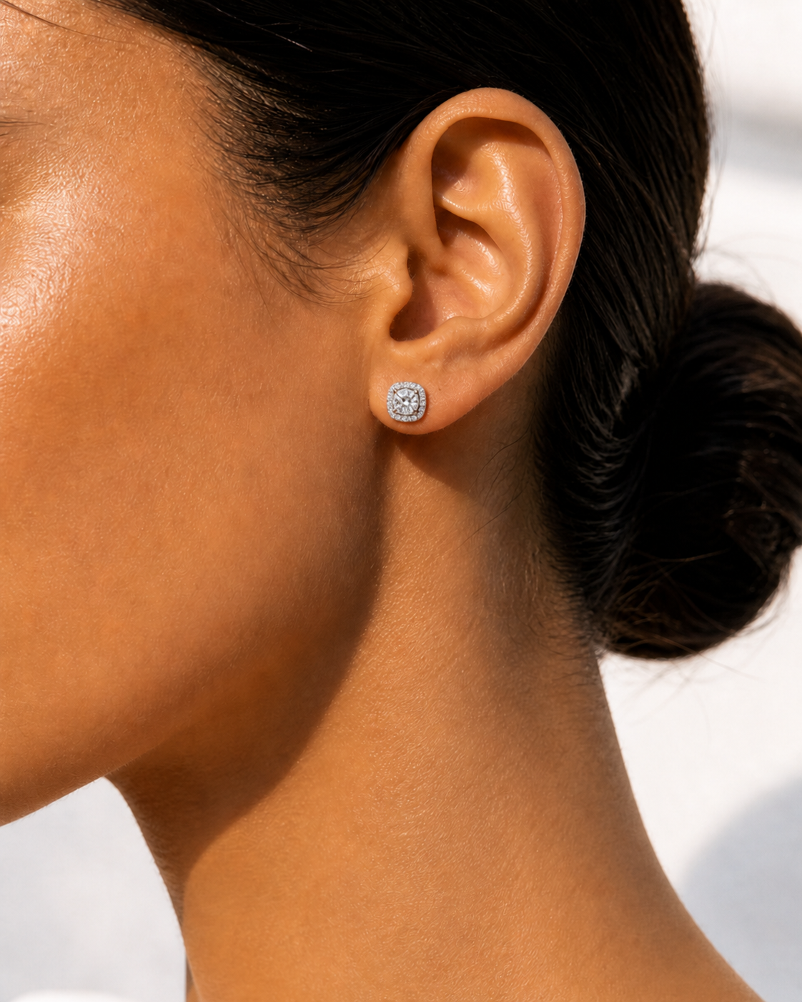 Model wearing 0.5 carat 5.0mm round moissanite halo stud earrings showcasing classic proportions.