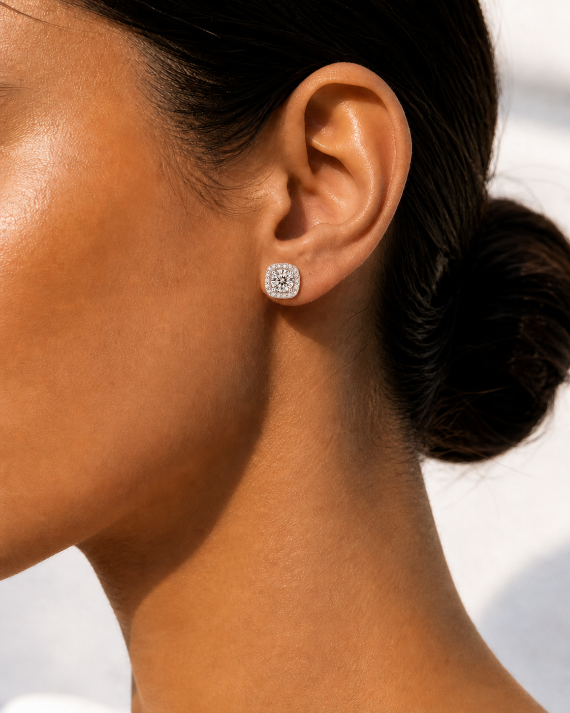 Model wearing 1.0 carat 6.5mm brilliant moissanite halo stud earrings for a luxury statement style.