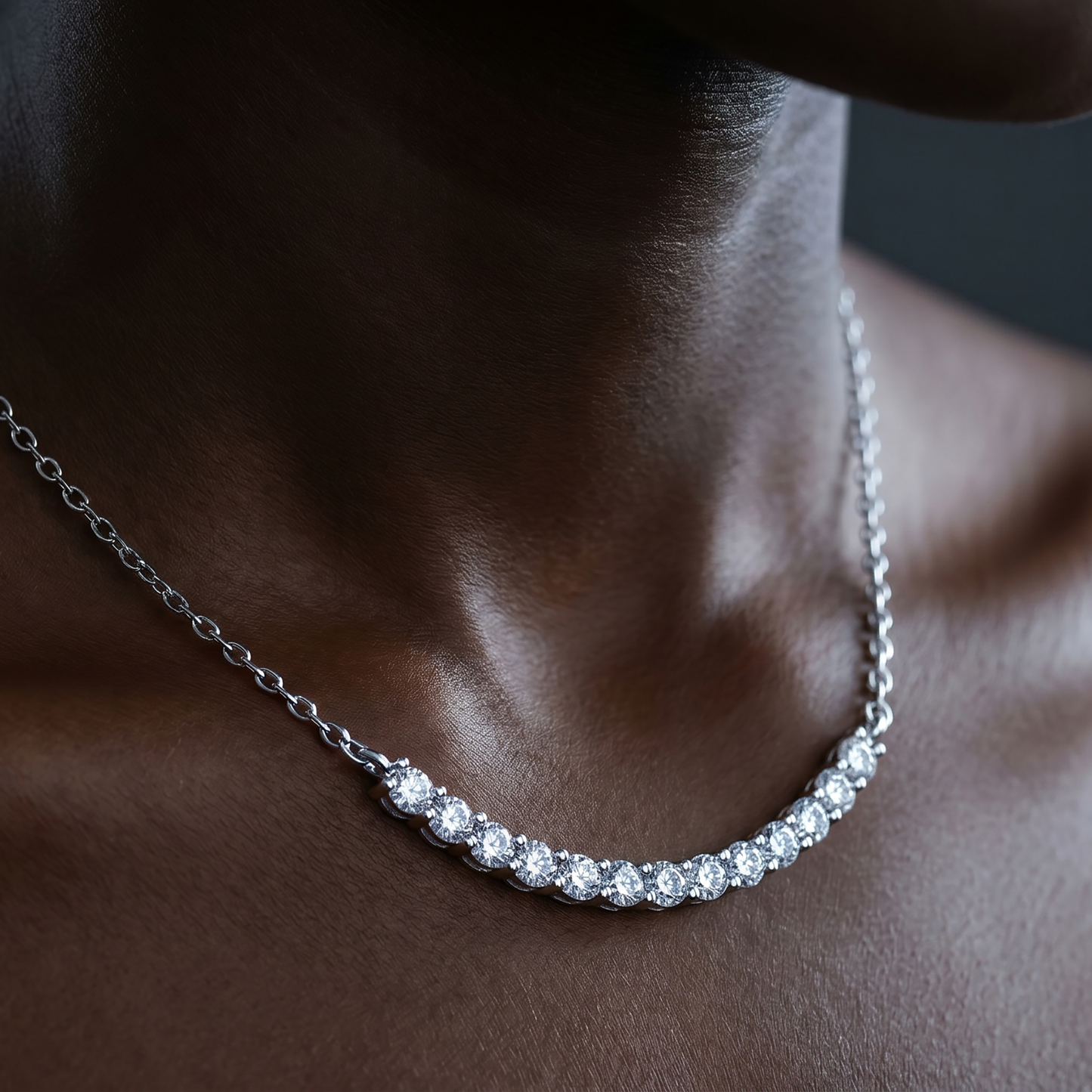 Close-up of curved moissanite bar necklace on deep skin tone