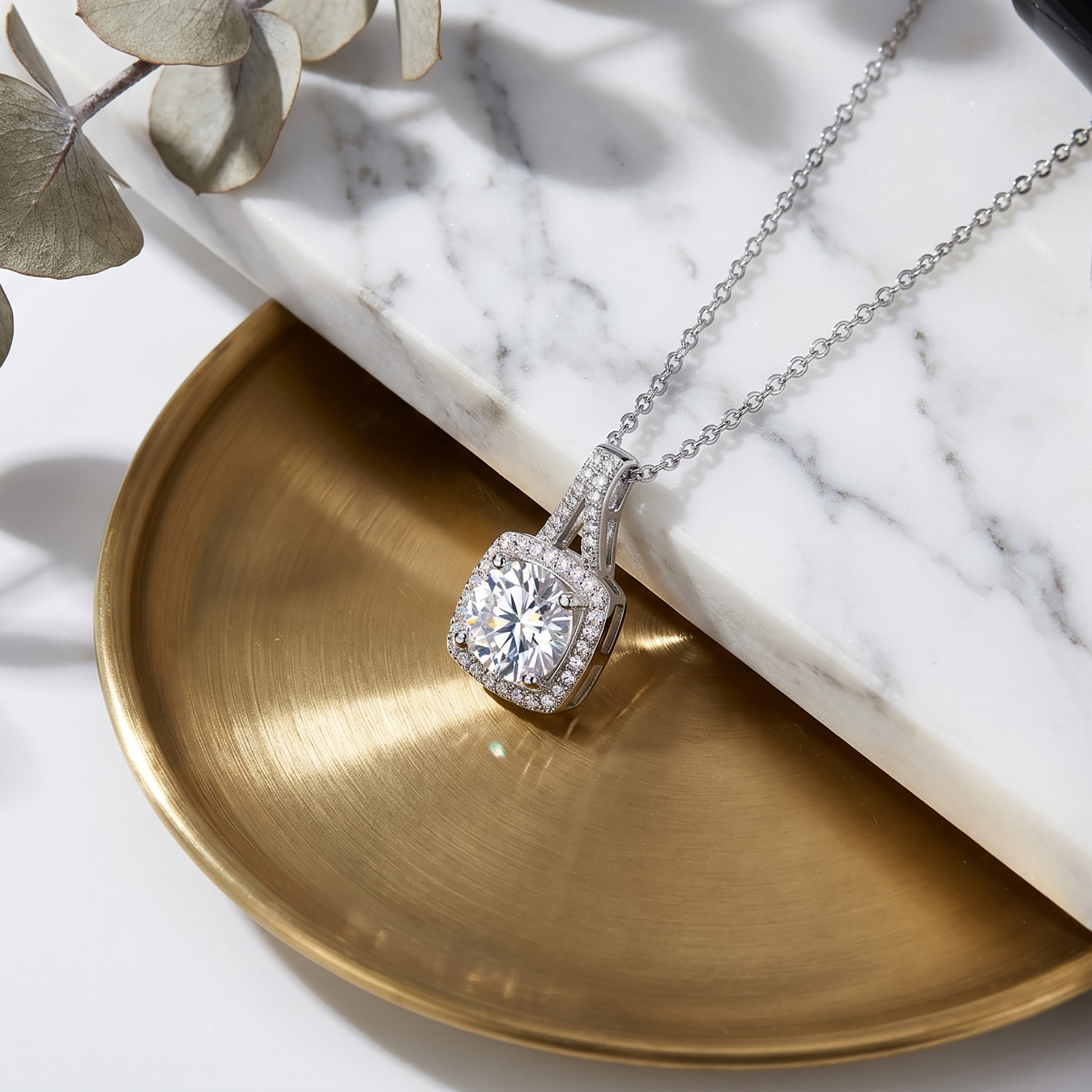 Cushion halo moissanite pendant necklace on marble with gold tray