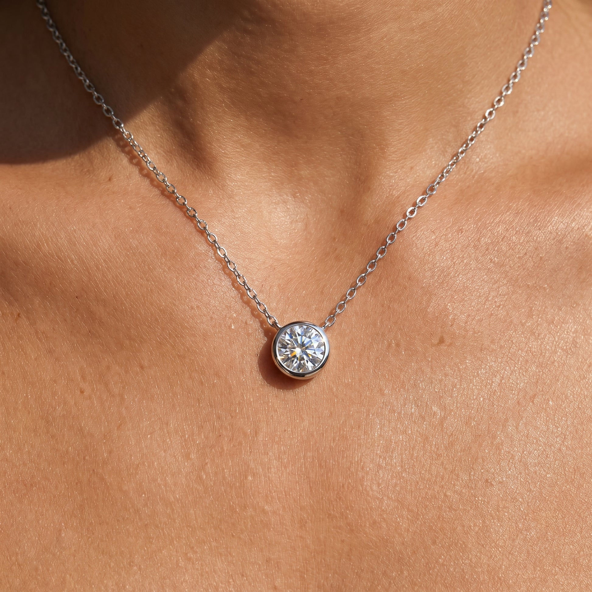 Silver and rose gold round moissanite pendant necklace, 925 sterling silver, bezel-set solitaire design, worn and product lifestyle images