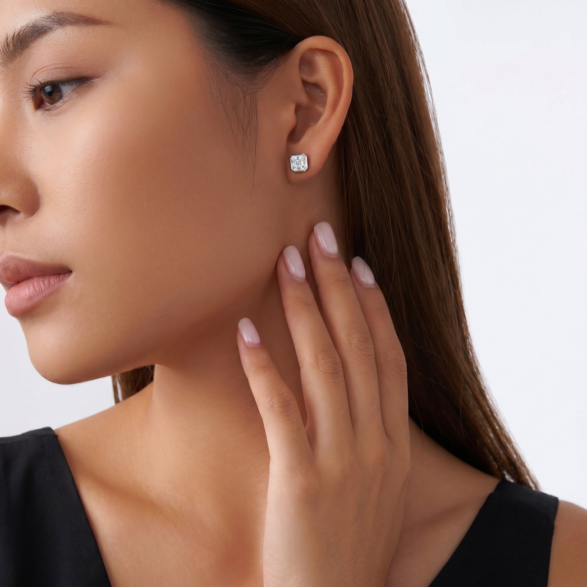 Modern structural step-cut Asscher moissanite earrings styled on a model in a minimalist quiet luxury fashion setting.