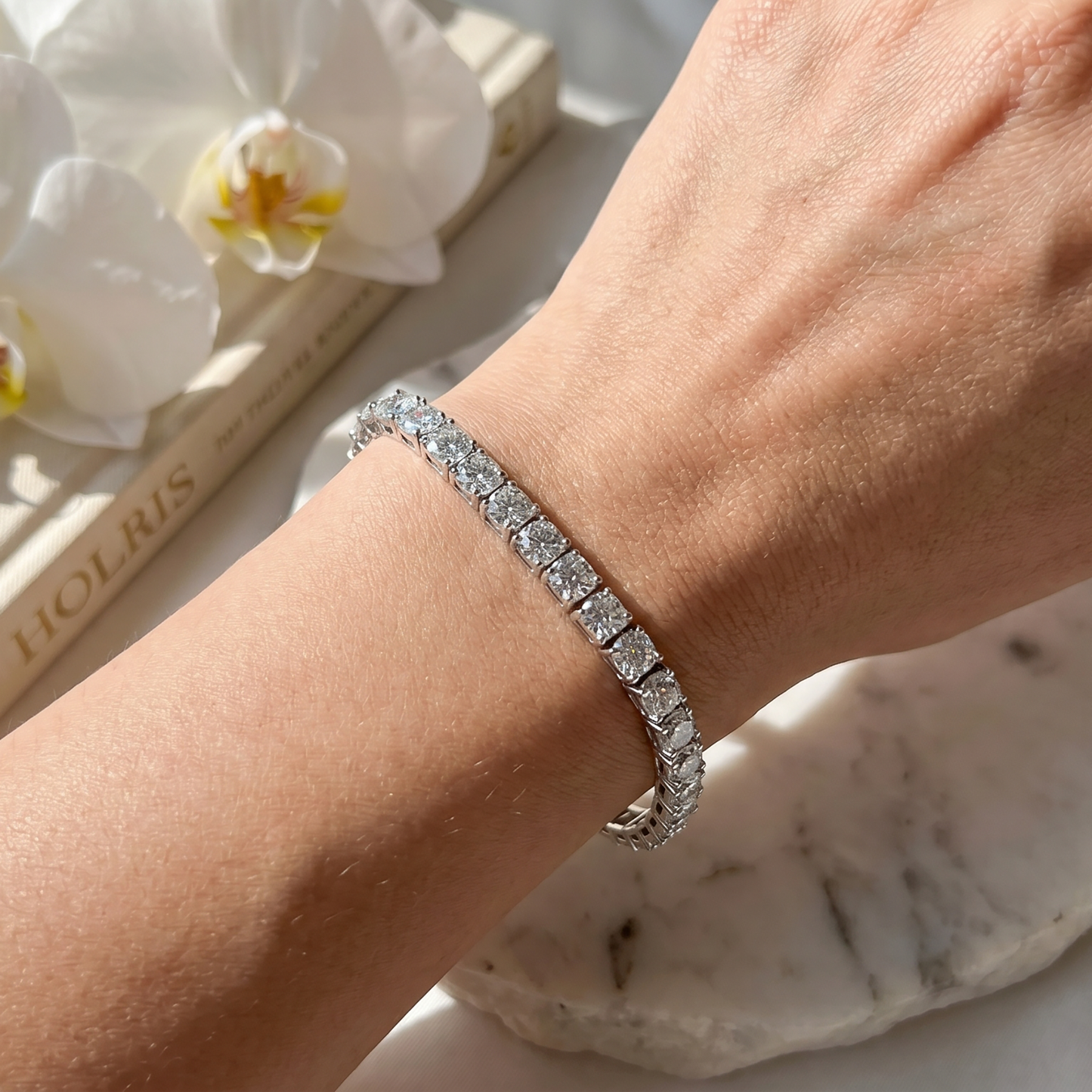 Close-up of moissanite tennis bracelet worn on wrist in natural light